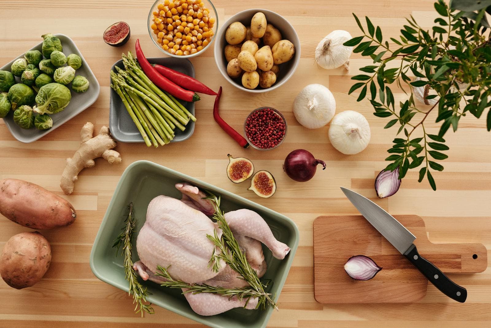 A farmers-garden spread of whole chicken, fresh vegetables, and herbs